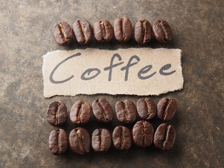 Coffee crop beans with text paper on wood texture backgroundの写真素材