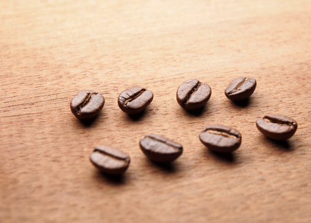 Coffee crop beans on wood texture backgroundの写真素材