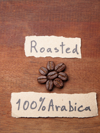 Coffee crop beans with text paper on wood texture backgroundの写真素材
