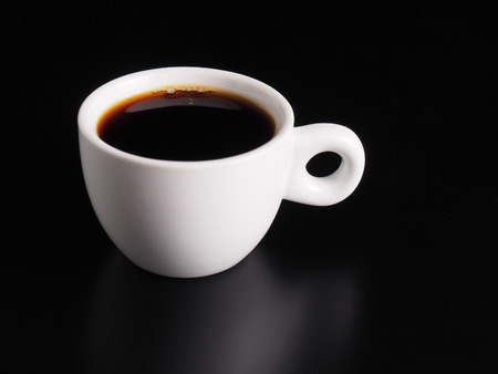 White Cup of hot black coffee on table with black backgroundの写真素材