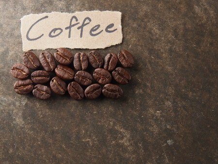 Coffee crop beans with text paper on wood texture backgroundの写真素材