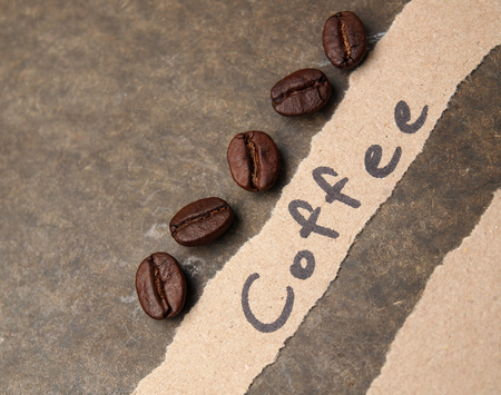 Coffee crop beans with paper on wood texture backgroundの写真素材