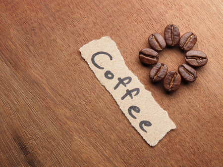 Coffee crop beans with text paper on wood texture backgroundの写真素材