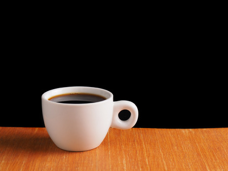 White Cup of hot black coffee on table with black backgroundの写真素材