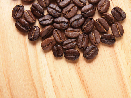 Coffee crop beans on wood texture backgroundの写真素材