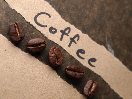 Coffee crop beans with paper on wood texture backgroundの写真素材