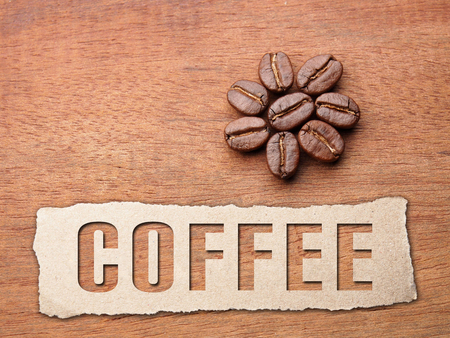 Coffee crop beans with paper and text on wood texture backgroundの写真素材