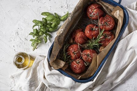 baked tomatoes with basil and rosemaryの写真素材