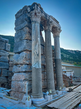 Fluted stone columns adorned with carved figures emerge powerfully from modern restoration...