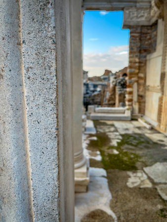 Prominent fluted marble column anchors the foreground, perfectly framing the iconic arched entrance...
