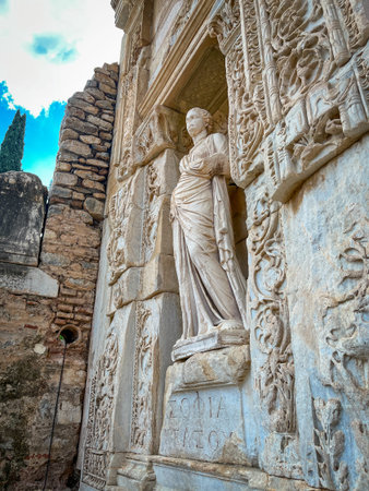 Draped marble figure stands serenely within the arched niche of the Library of Celsus, Greek...