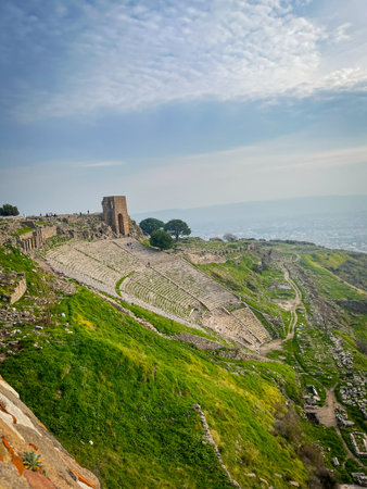 Constructed by Eumenes II of the Attalid Dynasty in the 2nd century BC, this Hellenistic theater in Pergamon stands as the steepest ancient structure on the Acropolis, near the Altar of Zeus, Temple of Dionysus, and Asclepeion. High-resolution capture reveals sharp details of weathered stones, vivid greens of surrounding hills, and azure skies with perfect clarity and intricate textures.の写真素材