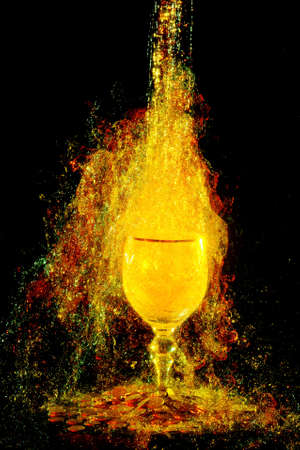 liquid falling down in the glass and coins near by at the black backgroundの写真素材