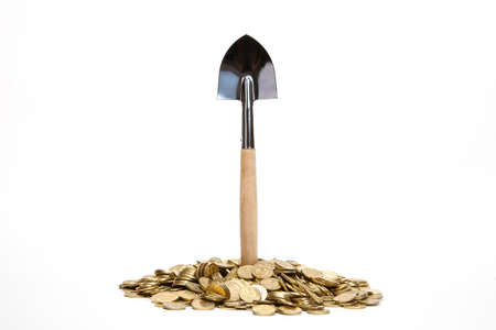 Shovel standing in pile of coins at white backgroundの写真素材