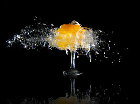 Raw egg is exploded into many pieces at black backgroundの写真素材