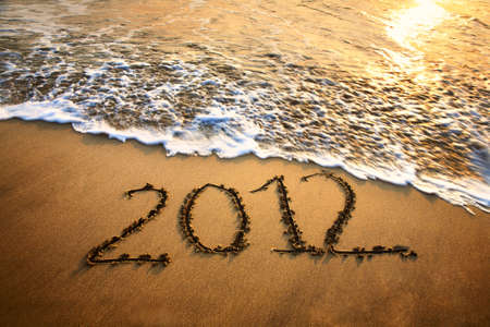 The welcome of the new year 2012 dramatic message in the sand at the beach near the oceanの写真素材