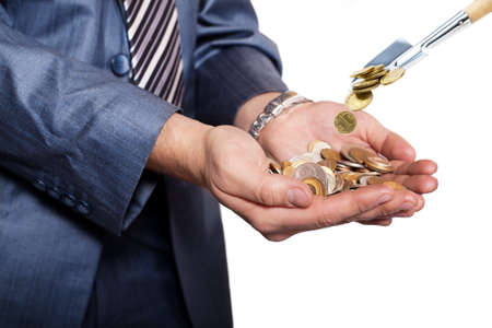 Businessman cups his hands as he holds a pile of coins. Money are threw to pile of coins by shovel の写真素材