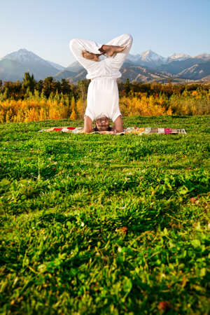 Yoga urdhva padmasana head standing with lotus pose by happy Indian Man