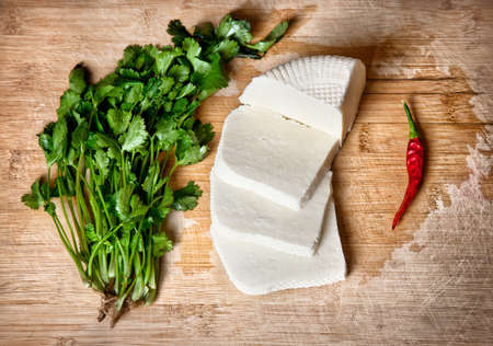 Brynza cheese, red chilli and bunch of fresh coriander on the deskの写真素材