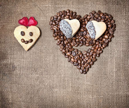 Funny Girl and boy from coffee beans, cookies and marmalades in shapes of heart on textured sack. Represent Valentines dayの写真素材