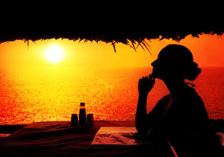 Young woman in restaurant waiting for dinner in Varkala, Kerala, Indiaの写真素材