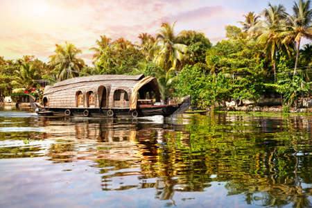 House boat in backwaters near palms at sunrise sky in Alappuzha, Kerala, Indiaの写真素材
