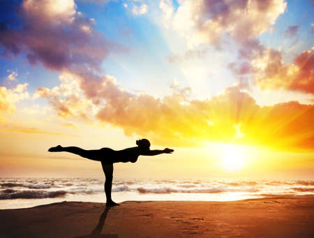Yoga virabhadrasana III, warrior pose by woman in silhouette with sunset sky background. Yoga virabhadrasana III, warrior pose by woman in silhouette with sunset sky background.