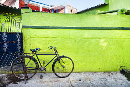 Bicycle near green wall on the street of Mamallapuram in Tamil Nadu, Indiaの写真素材