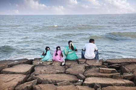 Puducherry, INDIA - January 26: Indian family sitting on the stones near the ocean in Puducherry, also known as Pondicherry, on January 26, 2013.のeditorial素材
