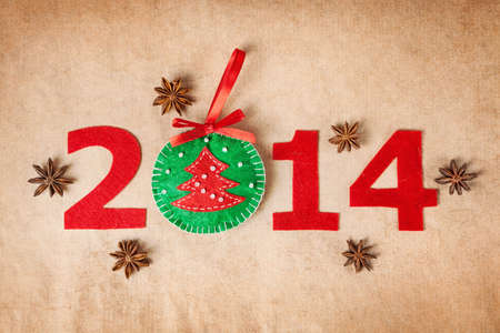 2014 new year with christmas toy from felt and star anise around on paper background