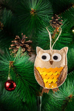 Handmade owl from felt on Christmas tree with conesの写真素材