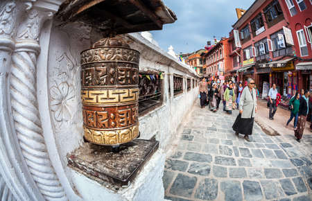 BODNATH, KATHMANDU, NEPAL - APRIL 6, 2014  Tibetan and Nepalese people walking around Bodnath stupa and prayer wheels  Bodnath is center of Buddhism pilgrimage in Nepalのeditorial素材