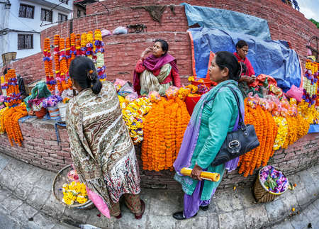 DURBAR SQUARE, KATHMANDU, NEPAL - APRIL 4, 2014  Woman selling flower garlands for prayer at street marketのeditorial素材