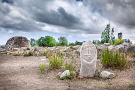 Ancient balbal statue in open air museum of Kyrgyzstan at overcast skyの写真素材