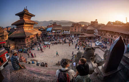 BHAKTAPUR, KATHMANDU VALLEY, NEPAL - APRIL 8, 2014: People preparing for celebration of new year with wooden chariot near Nepalese temples in shape of pagoda at Taumadhi Toleのeditorial素材