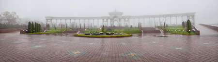 Panorama of entrance with arches and columns in the fog at dendra park of first president Nursultan Nazarbayev in Almaty, Kazakhstanの写真素材