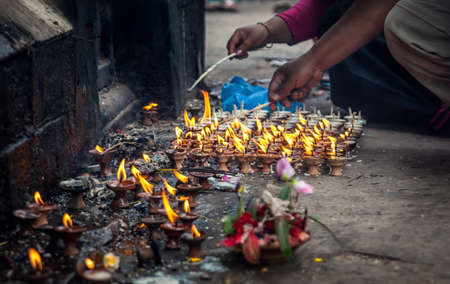 People lit up the oil lamps with flame near Hindu temple of Swayambhunath stupa in Kathmandu, Nepalの写真素材