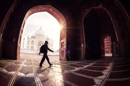 Tourist with backpack walking in the mosque arch near Taj Mahal in Agra, Uttar Pradesh, Indiaの写真素材
