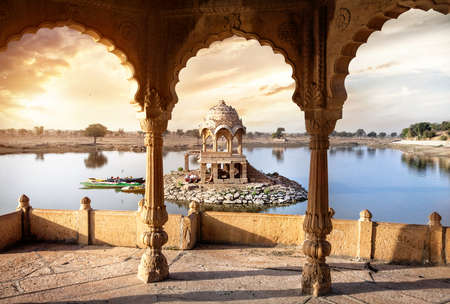 Arches and temple in Gadi Sagar lake at sunset sky in Jaisalmer, Rajasthan, Indiaのeditorial素材