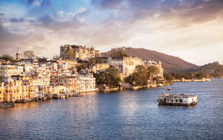 Lake Pichola with City Palace view at cloudy sunset sky in Udaipur, Rajasthan, Indiaのeditorial素材