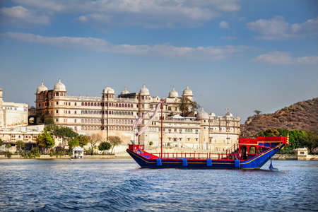 Boat on the Pichola lake with City Palace view at blue sky in Udaipur, Rajasthan, Indiaのeditorial素材