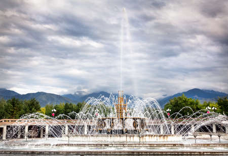 Big fountain at dramatic overcast sky in dendra park of first president Nursultan Nazarbayev in Almaty, Kazakhstanのeditorial素材