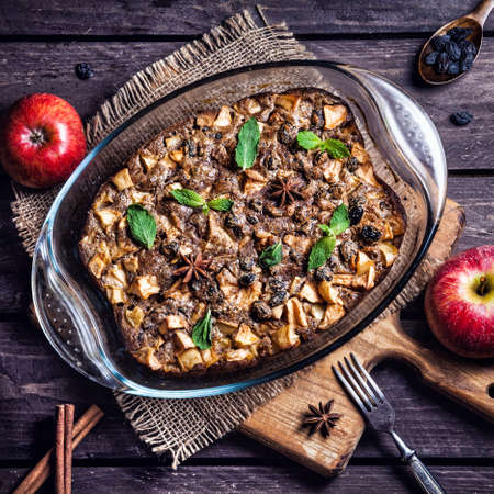 Homemade apple pie with cinnamon and raisins on the dark wooden backgroundの写真素材