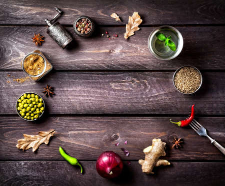 Spices and ingredients for the dish on the wooden background with space for textの写真素材