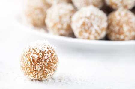 Indian Besan Ladoo sweets with coconut flakes close up on white backgroundの写真素材