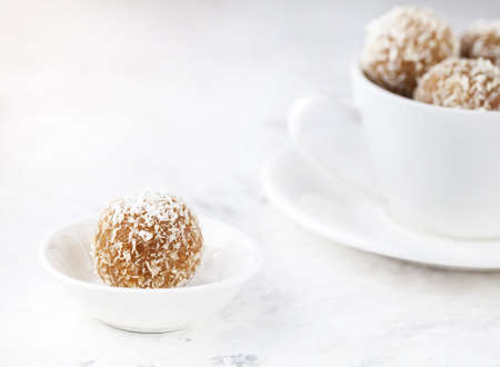 Indian Besan Ladoo sweets with coconut flakes close up on white backgroundの写真素材