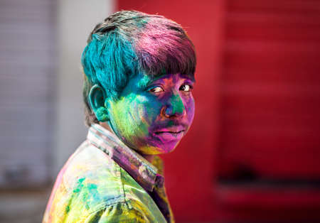 Udaipur, India - March 6, 2015: Portrait of Indian boy with painted face celebrating the colorful festival of Holi on the street.のeditorial素材