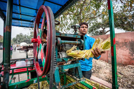 AGRA, UTTAR PRADESH, INDIA - FEBUARY 24, 2015: Young Indian man making sugarcane juice which is very famous in Indiaのeditorial素材