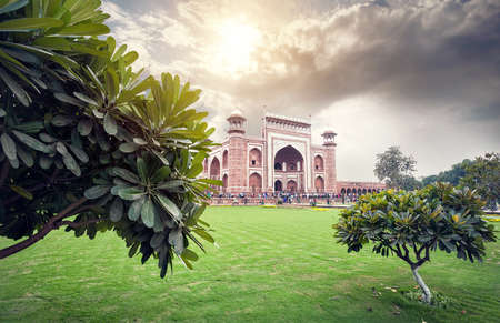 Main gate with towers in Taj Mahal complex one of the wonder of the world at cloudy sunset sky in Agra, Uttar Pradesh, Indiaの写真素材
