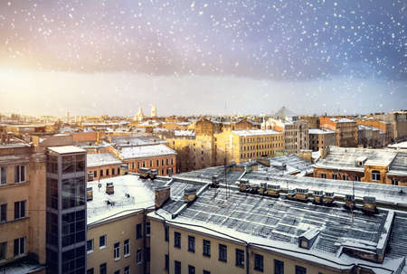 Panoramic view old buildings from the roof at snow fall at sunset in Saint Petersburg, Russiaの写真素材